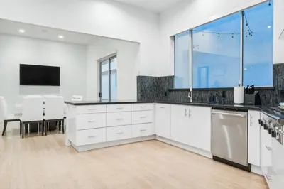 a kitchen with white cabinets and a large window at Hollywood Hills Luxury Nest Views Pool Spa in Los Angeles
