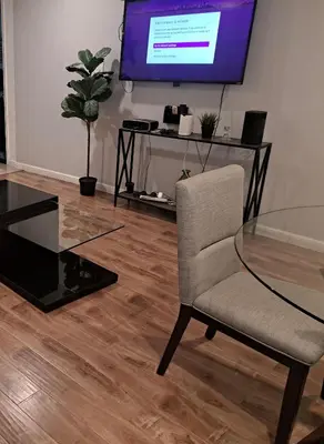 a room with a glass table and a chair and a television at 1 bedroom spacious apt in Beverly hills in Los Angeles