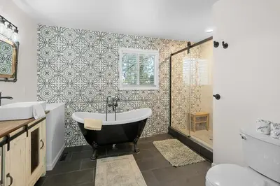 a bathroom with a tub and a toilet and a shower at Mockingbird Retreat - Walk to the Lake, hot tub, EV charger, Fenced yard. in Big Bear Lake