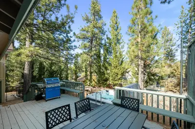 a deck with a picnic table and a swimming pool at Mockingbird Retreat - Walk to the Lake, hot tub, EV charger, Fenced yard. in Big Bear Lake
