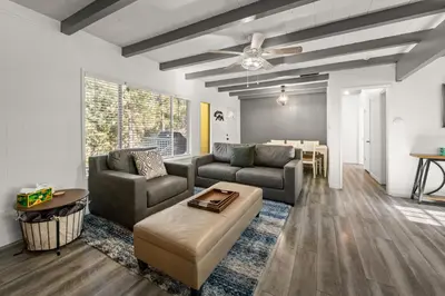 a living room with two couches and a table at Mockingbird Retreat - Walk to the Lake, hot tub, EV charger, Fenced yard. in Big Bear Lake