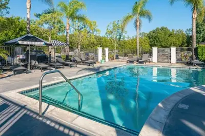 a swimming pool with palm trees in a resort at Newly Remodeled 2BR Apt | Mins to Disney | Arcade in Placentia