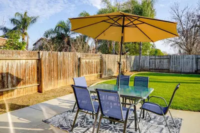 a table and chairs with an umbrella on a patio at BBQ Ready Home 7 Mi to The Park at River Walk in Bakersfield