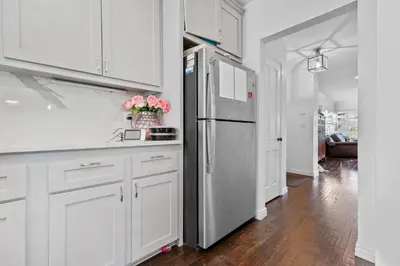 a kitchen with white cabinets and a stainless steel refrigerator at Luxury Pool Oasis- Near Stadium, Tennis and Golf in Pasadena