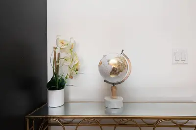 a table with a globe and a vase of flowers at Modern Hollywood Apt with Pool Spa & Great Views in Los Angeles