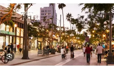 a group of people walking down a city street at Walk to Santa Monica Beach & Pier Boardwalk in Los Angeles