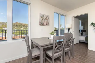 a dining room with a table and chairs and a balcony at Snazzy 3BR Apt Hollywood with Pool & Spa in Los Angeles