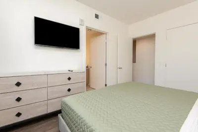 a bedroom with a bed and a tv on a wall at Snazzy 3BR Apt Hollywood with Pool & Spa in Los Angeles