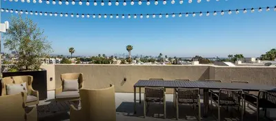 a patio with a table and chairs on a roof at Snazzy 3BR Apt Hollywood with Pool & Spa in Los Angeles