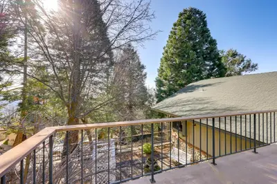 a balcony with a metal railing and trees at Mtn and Valley Views! Rimforest Lodge with Fireplace in Rimforest