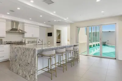a kitchen with a island with bar stools and a swimming pool at Spacious 4BR Retreat with Private Pool, Pool Table and Fast Wi-Fi Sleeps 9 Quiet Clinton Location in Beverly Hills