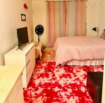a bedroom with a red rug on the floor at Cozy beautiful 2 bedroom home at the beach in Los Angeles