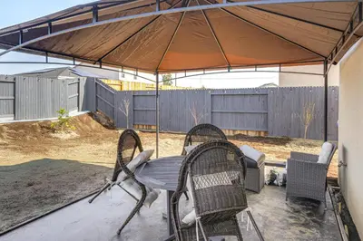 a table and chairs under an umbrella on a patio at Pet-Friendly Yard! Family Home in Bakersfield in Bakersfield