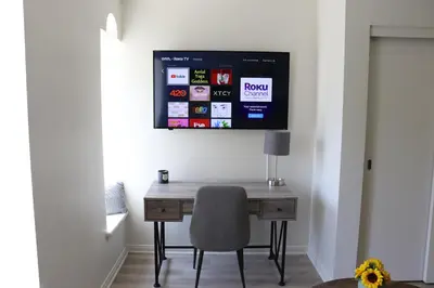 a desk with a chair and a tv on a wall at Promenade Studio With Free Parking in Los Angeles