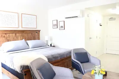 a bedroom with a bed and two chairs at Promenade Studio With Free Parking in Los Angeles