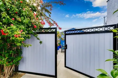 a pair of gates in a driveway with flowers at Mar Vista 2BR Retreat Office Huge Backyard in Los Angeles