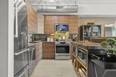 a large kitchen with wooden cabinets and stainless steel appliances at Luxe DTLA Escape - Walk to Games, Events, & Dining in Los Angeles