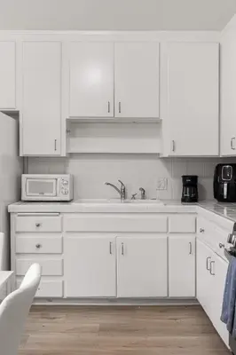 a white kitchen with white cabinets and a microwave at Relax in Stylish 3BR with Fire Pit Gym and Parking in Los Angeles