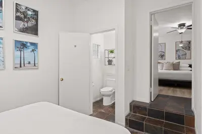 a white bedroom with a bed and a bathroom at Relax in Stylish 3BR with Fire Pit Gym and Parking in Los Angeles