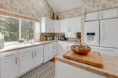 a kitchen with white cabinets and a wooden bowl on a counter at Deer Creek Lodge Mtn Getaway in Lake Arrowhead! in Lake Arrowhead