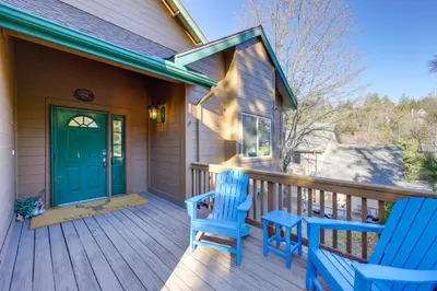 a porch with two blue chairs and a green door at Deer Creek Lodge Mtn Getaway in Lake Arrowhead! in Lake Arrowhead