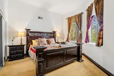 a bedroom with a large wooden bed and two windows at Hillside Retreat Near Universal Studios & Hollywood Sign in Los Angeles