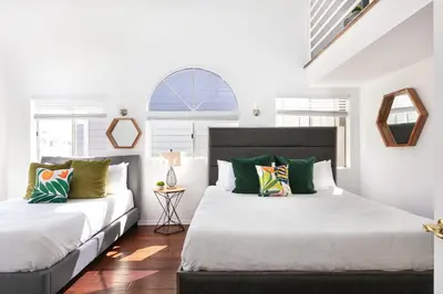 two beds in a bedroom with white walls at Luxury 4BR Townhouse Sleeps 10 with Parking in McNeil