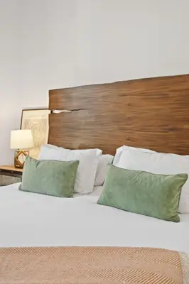 a bed with two green pillows and a wooden headboard at Luxury Marina Penthouse Private Suite with Pool in Los Angeles