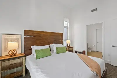 a bedroom with a large white bed with two green pillows at Luxury Marina Penthouse Private Suite with Pool in Los Angeles