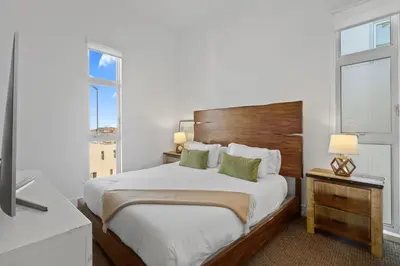 a bedroom with a large bed and two windows at Luxury Marina Penthouse Private Suite with Pool in Los Angeles