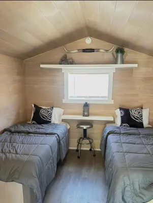 two beds in a small room with a window at Zaromelranch