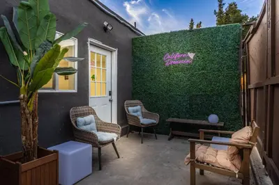 a patio with chairs and a green wall at Sleek Premium Studio Near The Grove & Fairfax in Los Angeles