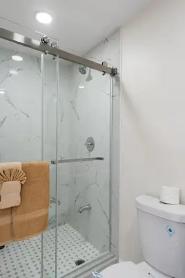a bathroom with a glass shower with a toilet at Sleek Premium Studio Near The Grove & Fairfax in Los Angeles