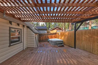 a wooden pergola over a patio with a grill at Highland Cedar Cabin WHot Tub Close to Village in Big Bear Lake