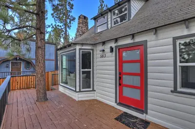 a house with a red door on a patio at Highland Cedar Cabin WHot Tub Close to Village in Big Bear Lake