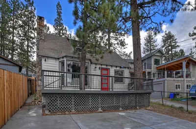 a house with a large balcony with a red door at Highland Cedar Cabin WHot Tub Close to Village in Big Bear Lake