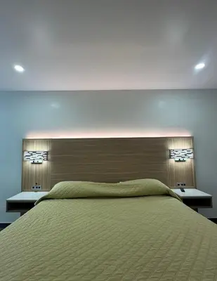 a bedroom with a large green bed with two night stands at Nubell Motel in Bell