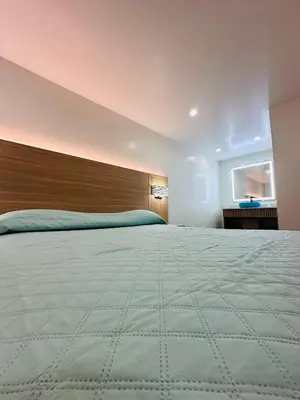 a bedroom with a large bed with a wooden headboard at Nubell Motel in Bell