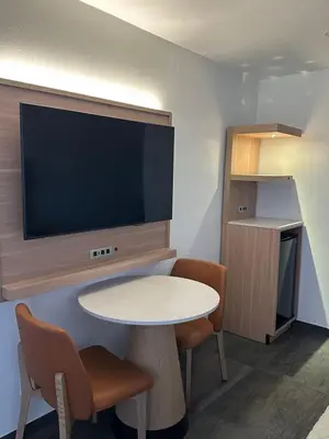 a room with a table and a flat screen tv at Nubell Motel in Bell