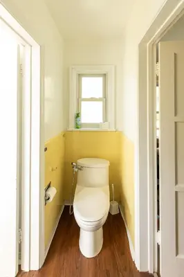 a white toilet in a bathroom with a window at The Rochester house in Los Angeles