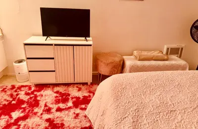 a bedroom with two beds and a tv on a dresser at Cozy private room in Santa Monica in Los Angeles