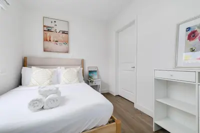 a bedroom with a white bed with towels on it at Mar Vista Beach Escape 2BR with Relaxing Yard in Los Angeles