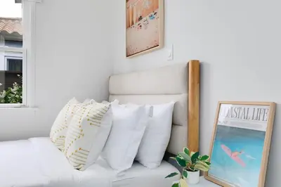 a living room with a white couch with pillows at Mar Vista Beach Escape 2BR with Relaxing Yard in Los Angeles