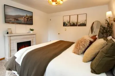 a bedroom with a large bed with a fireplace at In the Pines Romantic Big Bear Forest Cabin in Fawnskin