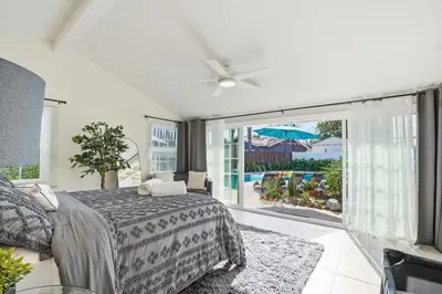 a bedroom with a bed and a balcony with an umbrella at 4BR Home near Universal - Private Pool, BBQ, Free Parking in Hickson