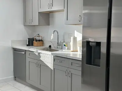 a kitchen with white cabinets and a stainless steel refrigerator at Walkable to SoFi, Intuit Dome, Kia Forum World Cup in Inglewood