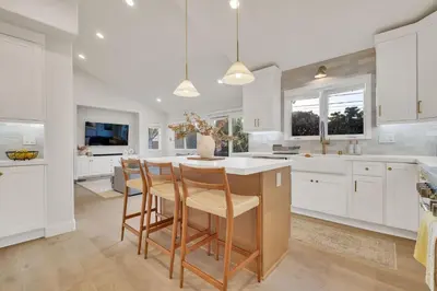 a kitchen with white cabinets and a table and chairs at Luxury Retreat with Private Yard close to Beaches and FIFA Sleeps 10 in Torrance