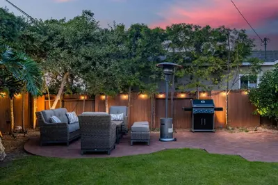 a patio with chairs and a grill in a backyard at Luxury Retreat with Private Yard close to Beaches and FIFA Sleeps 10 in Torrance