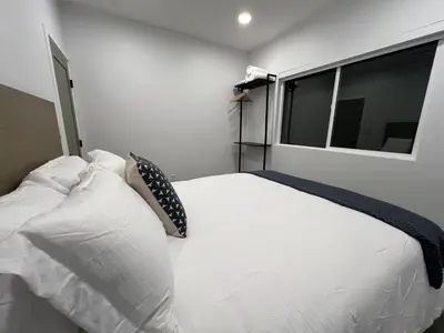 a bedroom with a white bed with pillows and a window at Castaway Cay near Disney with Hot Tub and Fire Pit in Anaheim