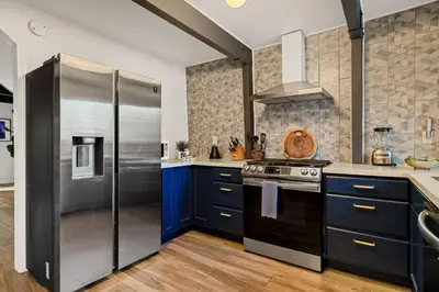 a kitchen with blue cabinets and a stainless steel refrigerator at Hearthmoon Haven in Big Bear Lake
